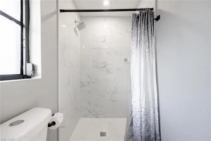 Bathroom with a shower stall and toilet