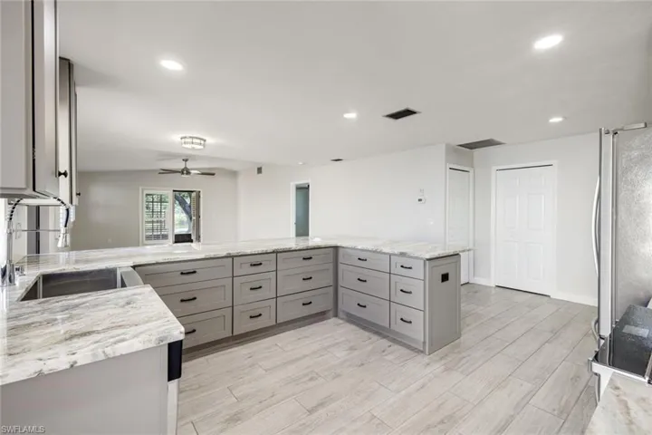 Kitchen offers light gray custom cabinetry with built in pop power in the center of the granite island, stainless sink, upgraded fixtures and stainless steel appliances!  Lots of storage on both sides of the island cabinetry!