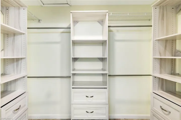 Oversized walk-in custom closet with built in shelving and drawers.
