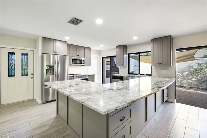 This totally remodeled kitchen opens up to the entire villa, offering an open concept which is overlooking the massive open, privacy walled patio and the separate huge, screened lanai which overlooks a gorgeous Live Oak and lake.