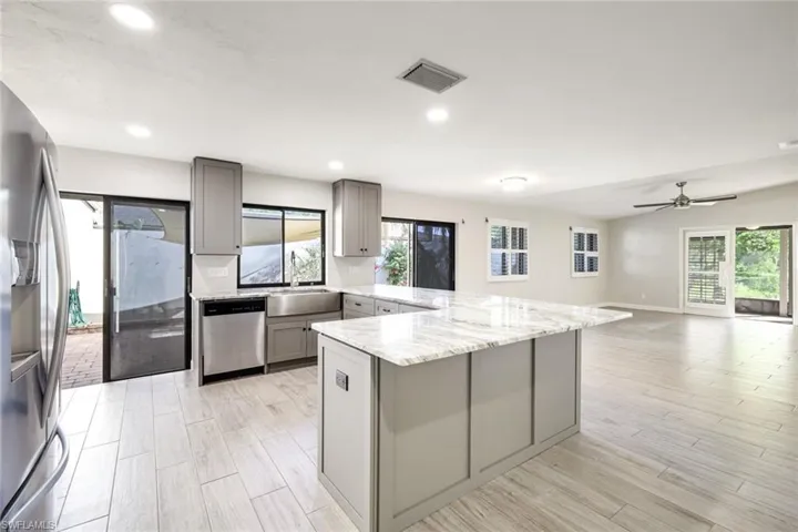Kitchen offers light gray custom cabinetry with built in pop power in the center of the granite island, stainless sink, upgraded fixtures and stainless steel appliances!