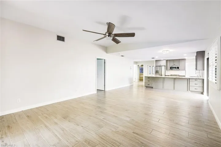 Living/dining room area with kitchen in the background and guest bedroom area offering extra closets, guest bath and bedroom.