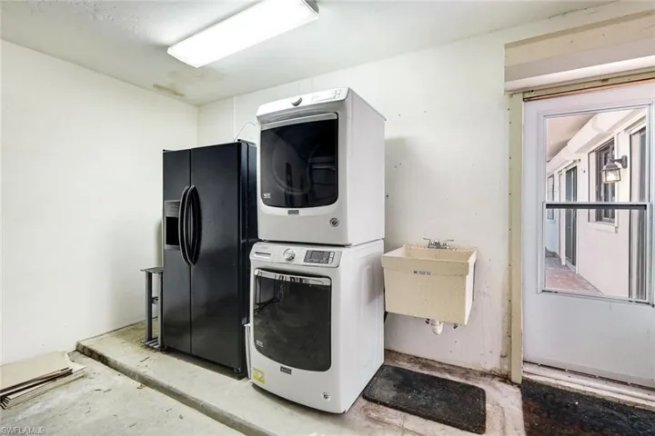 2 car garage with extra French door refrigerator and stack front load washer and dryer.  Extra storage shelving and access to the outdoor, private patio!