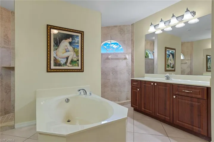 Bathroom with tile flooring, separate shower and tub, and vanity