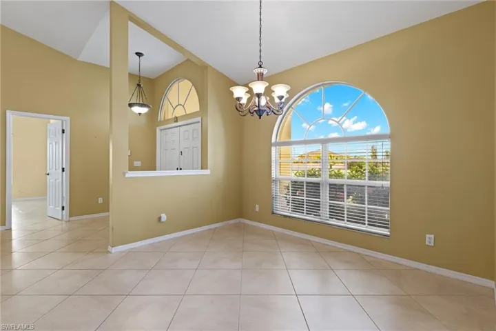 Tiled empty room with an inviting chandelier