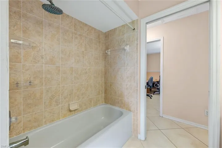 Bathroom with tile floors and tiled shower / bath combo