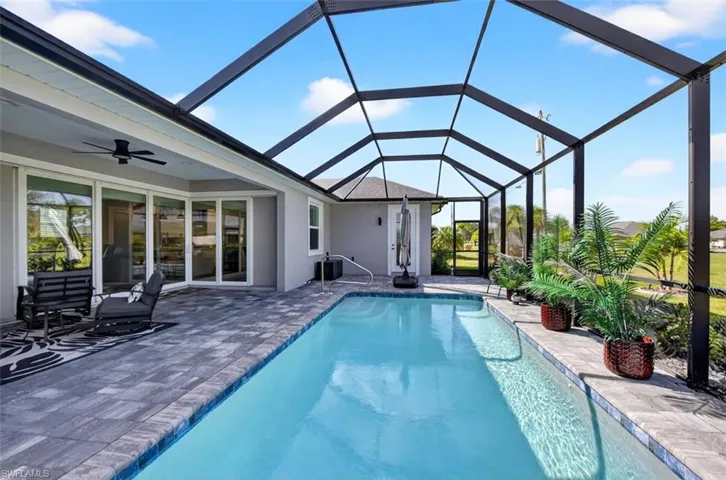 Swimming pool with a lanai, a sunroom, and a patio area