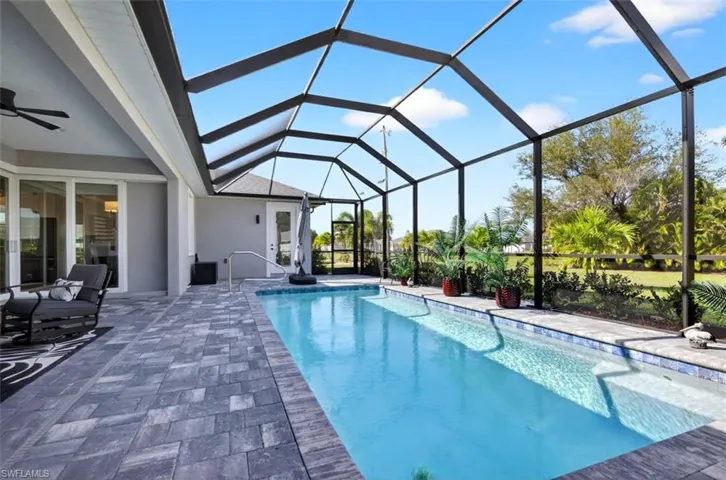 Swimming pool featuring a sunroom, glass enclosure, and a patio area