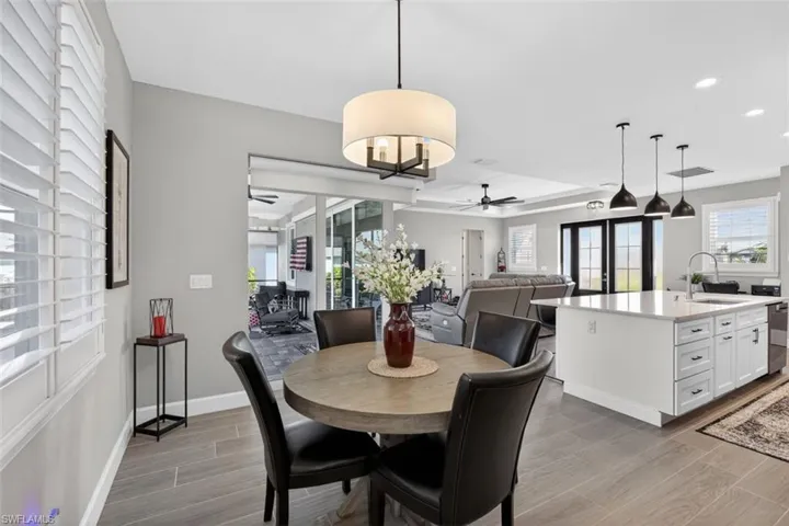 Dining room featuring wood tiled floors, healthy amount of natural light, recessed lighting, and ceiling fan