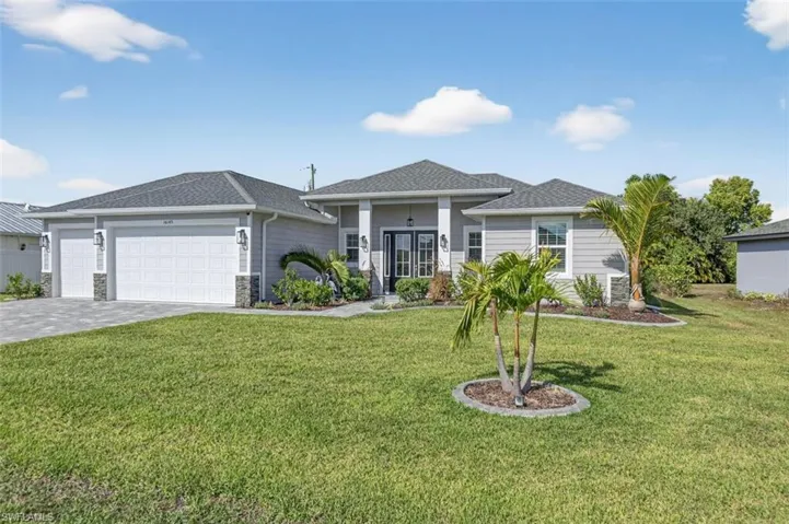 View of front of property featuring a front yard, an attached garage, decorative driveway, and roof with shingles