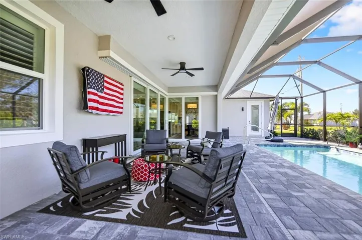 View of patio / terrace with a sunroom, a ceiling fan, an outdoor hangout area, glass enclosure, and an outdoor pool