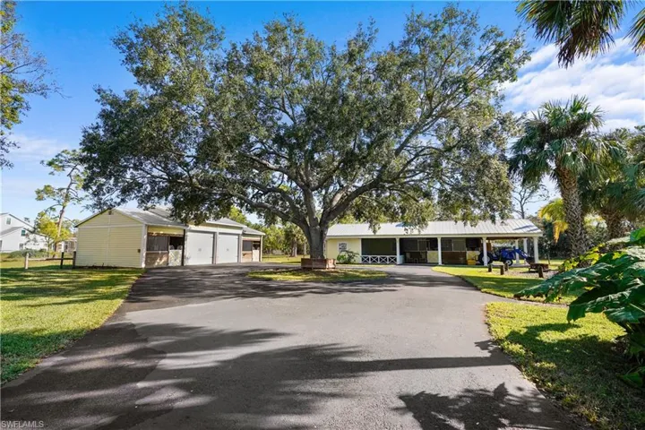 All the buildings are well maintained and painted to match. The asphalt circle drive ties it all together. To the left is an outbuilding with 2 oversized stalls and a oversized double garage. Straight ahead is an outbuilding with 1 bed, 1 bath apartment with screen porch, two stalls each with it's own paddock, large covered area with wash area with enclosed shower and sink.