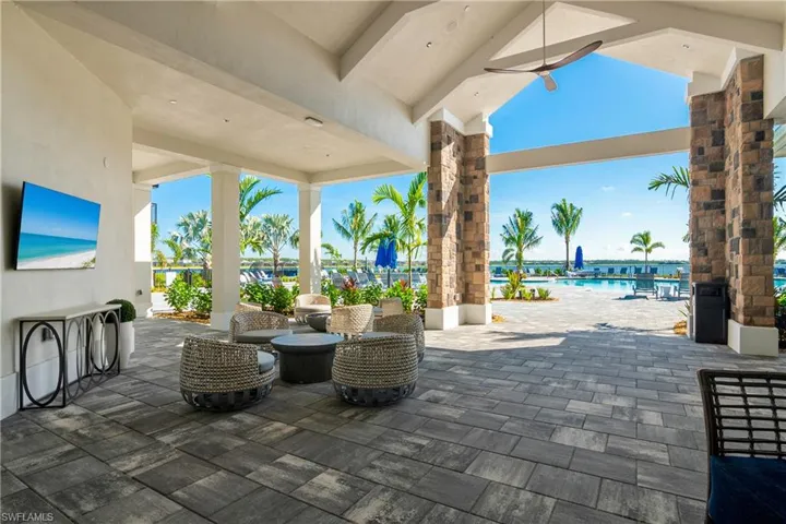 View of patio / terrace with a community pool, ceiling fan, and a water view