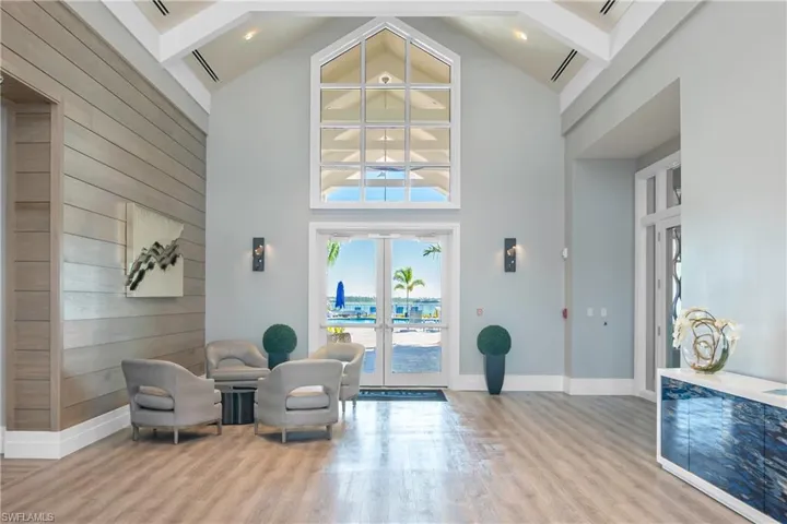 Sitting room featuring french doors, wood walls, and high vaulted ceiling