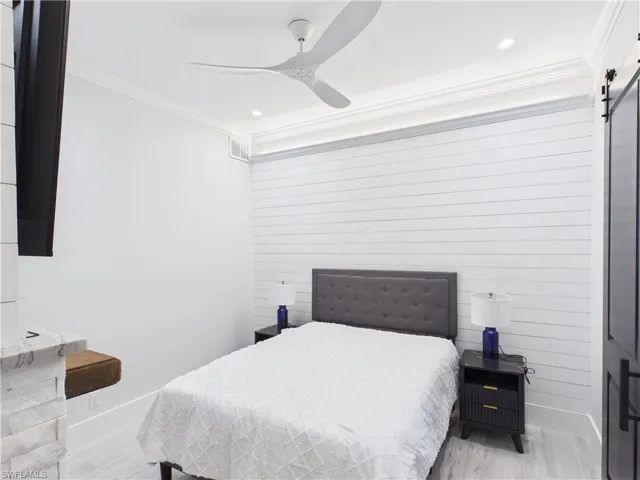 Bedroom featuring a shiplap accent wall, crown molding, and recessed lighting