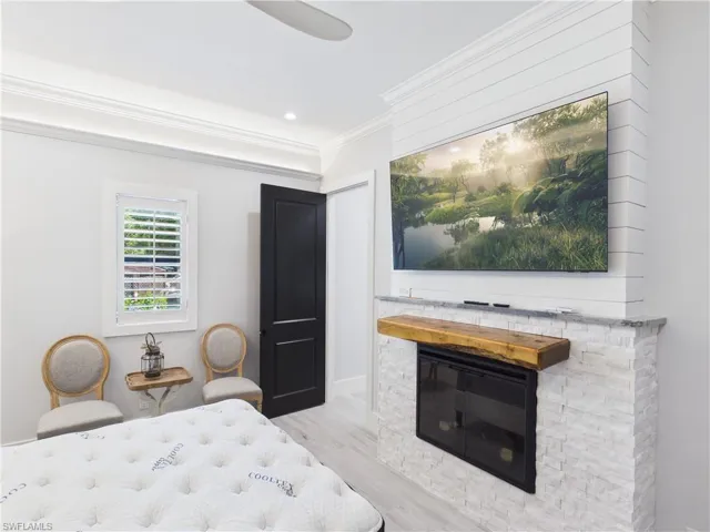 Fireplace featuring a stacked stone surround, wood mantel, and integrated television
