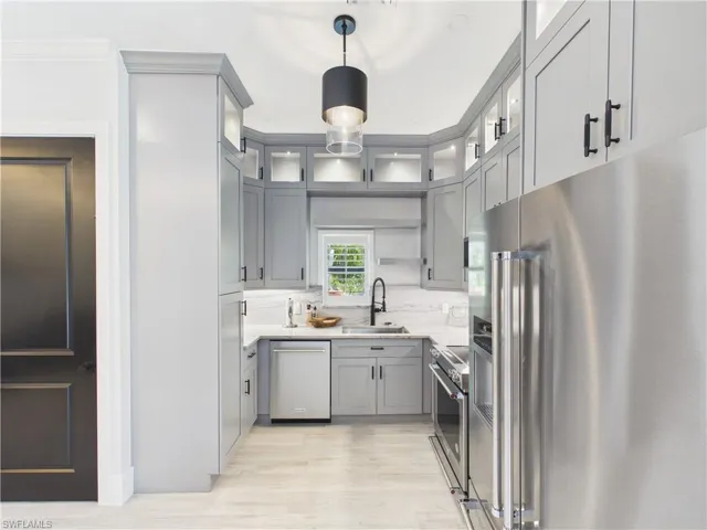 Kitchen with light gray cabinetry, stainless steel appliances, white marble-look countertops, and recessed lighting