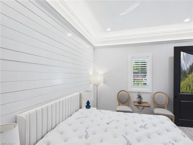 Accent shiplap wall paired with crown molding and recessed lighting