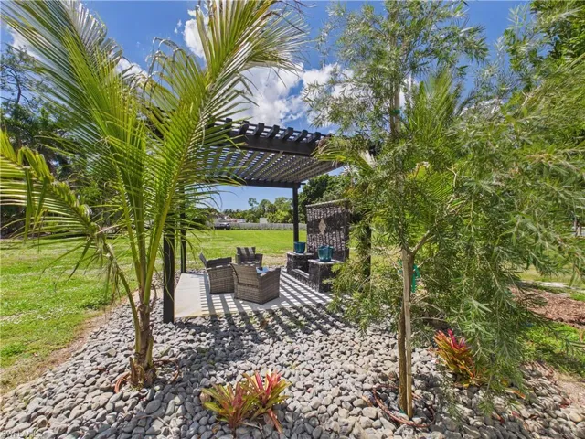 Outdoor pergola structure with a slatted roof, featuring a concrete patio base