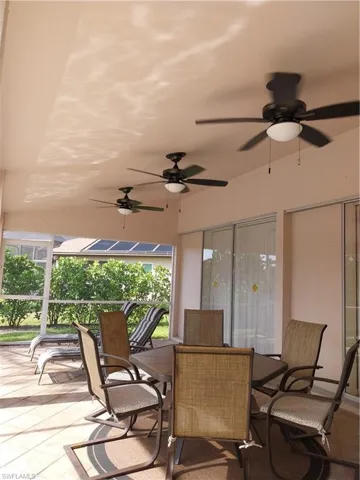 Sunroom / solarium with a ceiling fan and outdoor dining space