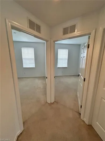 Corridor featuring carpet and baseboards