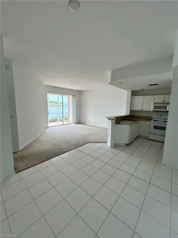 Unfurnished living room featuring light tile patterned flooring and a water view