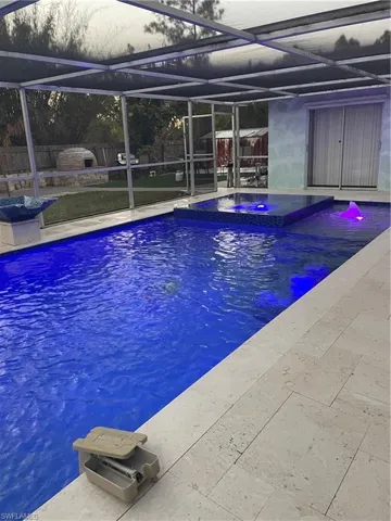 Integrated pool / spa featuring glass enclosure and a sunroom