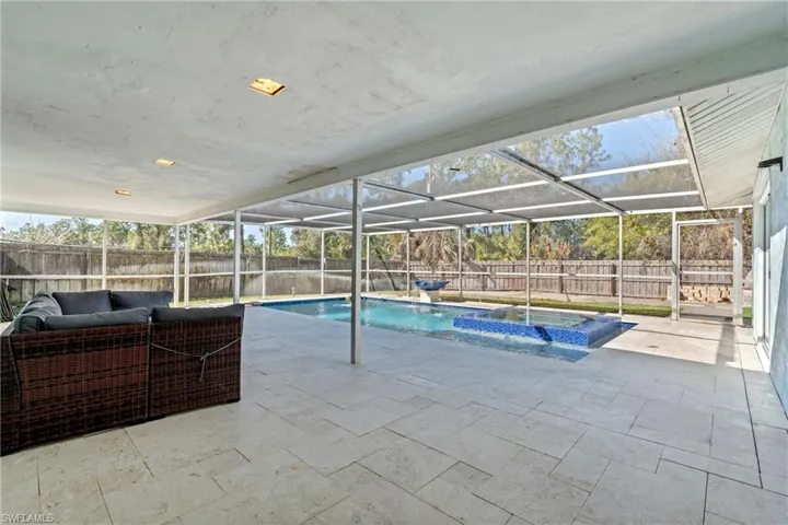 Relaxing pool / spa featuring a sunroom, a patio area, outdoor lounge area, glass enclosure, and a fenced backyard