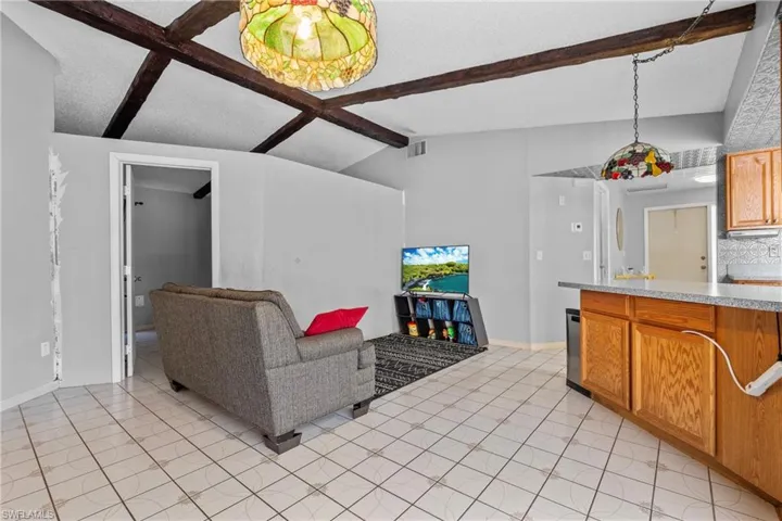 Living room with light tile patterned floors and coffered ceiling