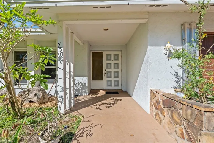 Entrance to property with stucco siding