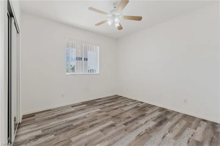 Unfurnished bedroom featuring light wood finished floors, a closet, and a ceiling fan