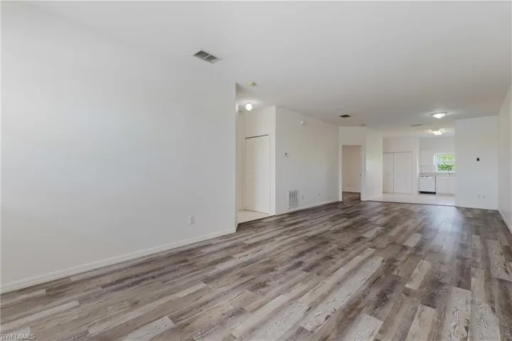 Unfurnished living room featuring light wood-style flooring and baseboards