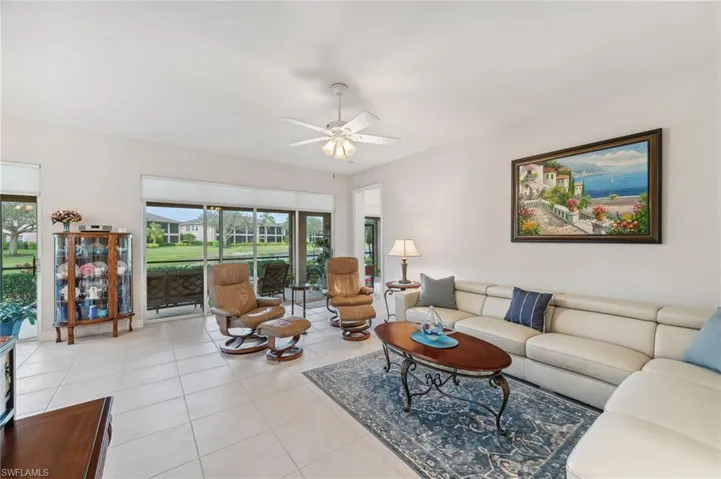 Tiled living area featuring expansive slider walls, water views and a healthy amount of sunlight