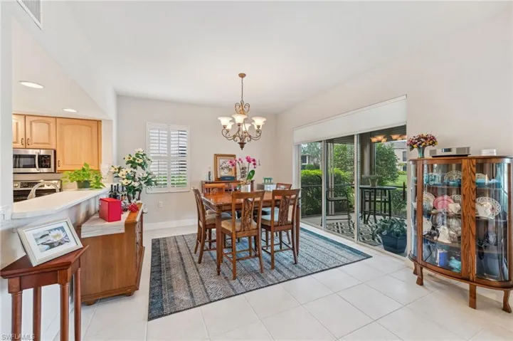 Dining area featuring plenty of natural light, light tile patterned floors, and a notable chandelier