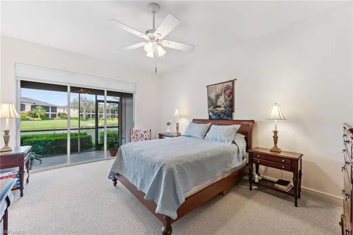 Primary bedroom with ceiling fan, access to exterior, and light carpet