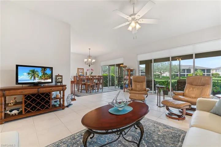 Tiled living/dining room with expansive slider wall leading to waterfront lanai