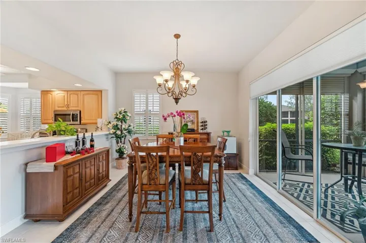 Tiled dining room with a wealth of natural light and a notable chandelier