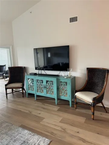 Sitting room featuring wood finished floors and a towering ceiling