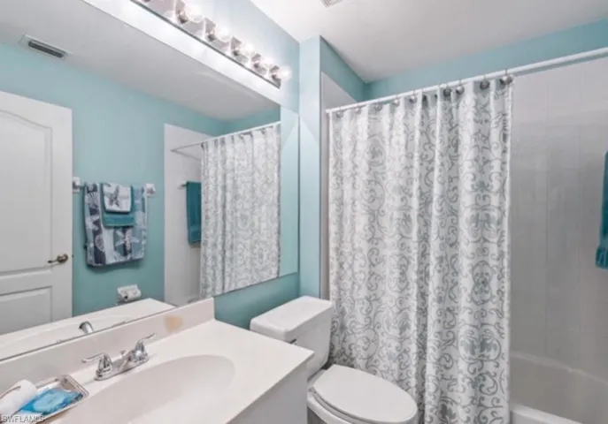 Full bathroom with vanity and shower / bath combo with shower curtain