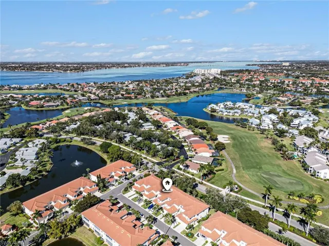 Aerial perspective of suburban area featuring a nearby body of water and a golf club