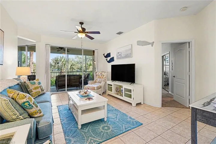 Living room with light tile patterned floors and ceiling fan