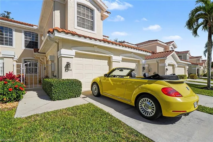 Mediterranean / spanish home with stucco siding, driveway, a tile roof, and an attached garage