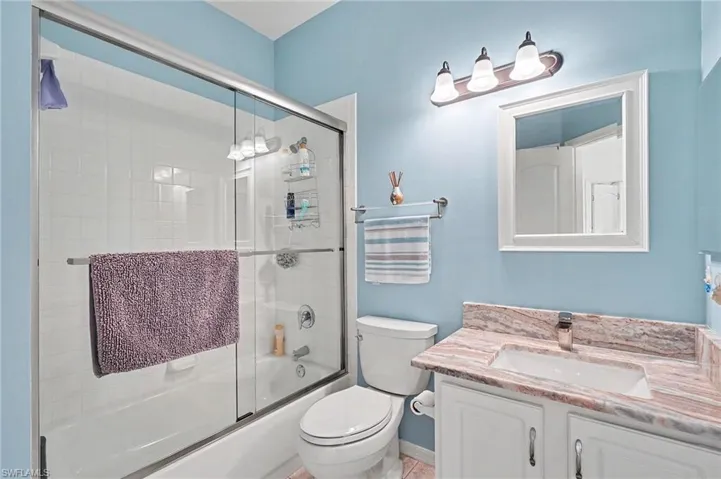 Bathroom with enclosed tub / shower combo and vanity