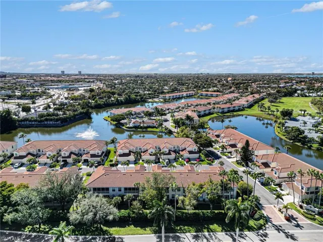 Aerial perspective of suburban area featuring a nearby body of water and a golf course