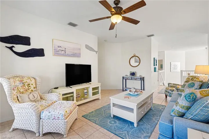 Living area with ceiling fan and tile patterned flooring