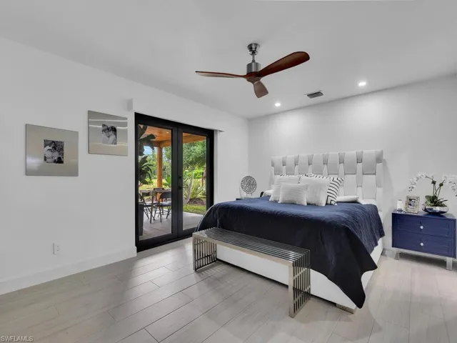 Bedroom with wood-type flooring, ceiling fan, french doors, and access to outside