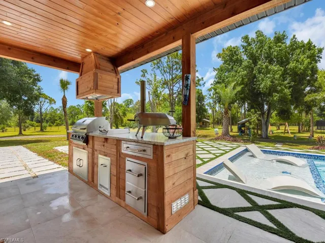 View of terrace featuring a grill, exterior kitchen, and a pool