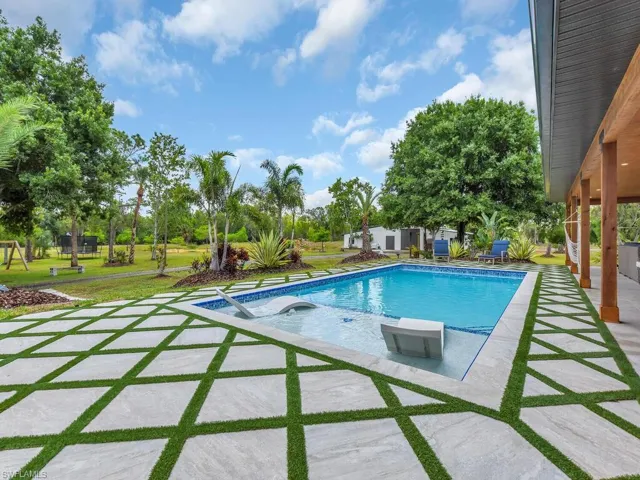 View of pool with a lawn and a patio