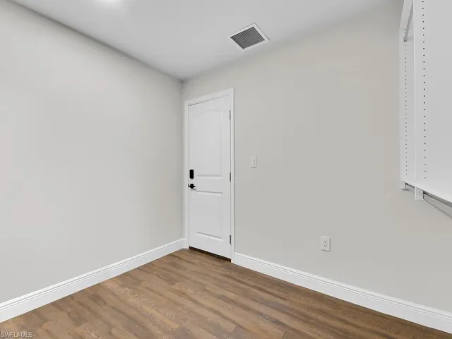 Spare room with dark wood-type flooring