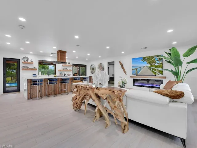 Living room with light hardwood / wood-style floors and indoor bar